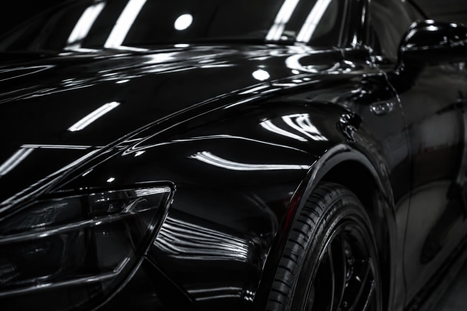 Glossy black car fender with flawless paint reflection